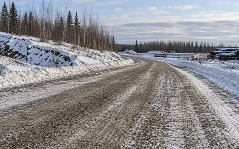 Sand aggregate on a snowy industrial access road